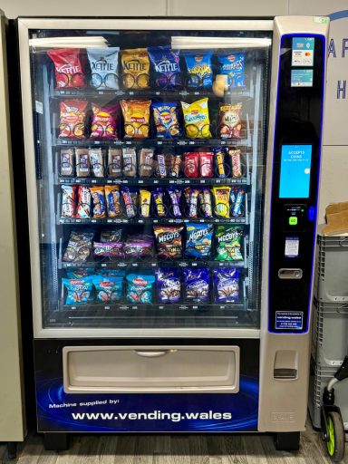 A vending machine filled with various snacks and cold drinks.